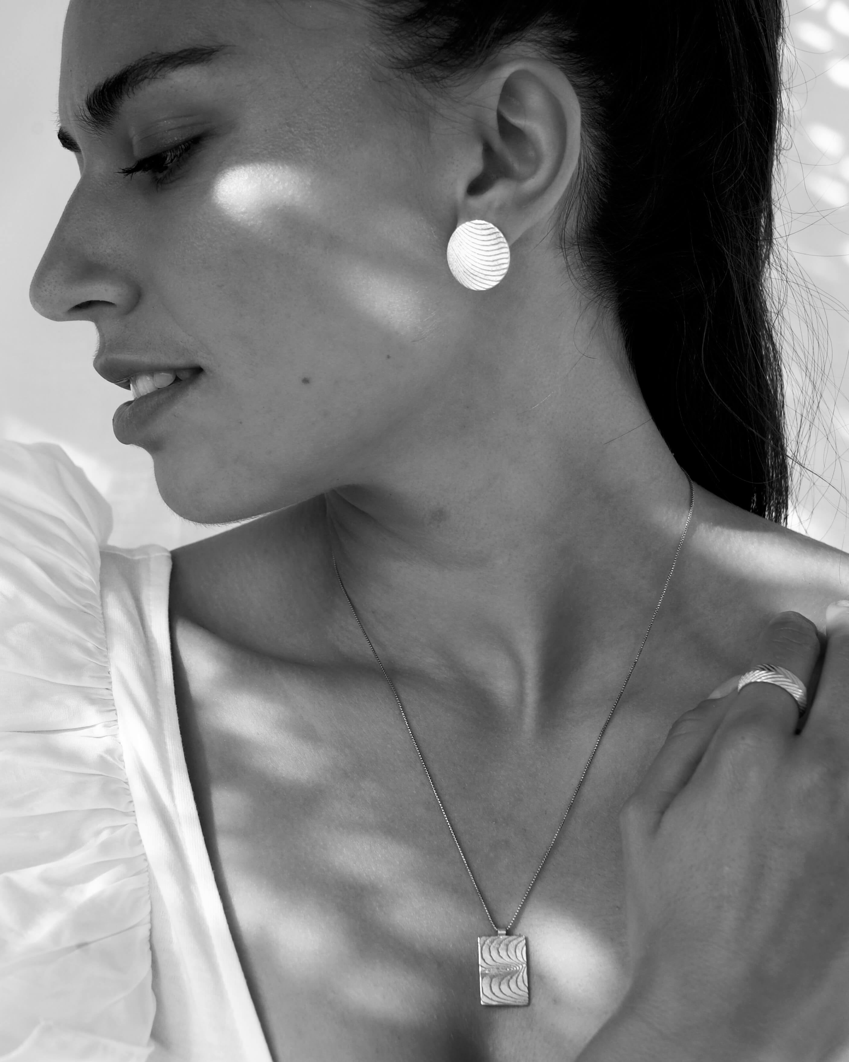 Goldenesoder silbernes Rechteck mit maritimen Wellen. Das Geheimnis toller Frauen lliegt in ihrer Authentizität und ihrem Mut, besonderen Schmuck zu tragen