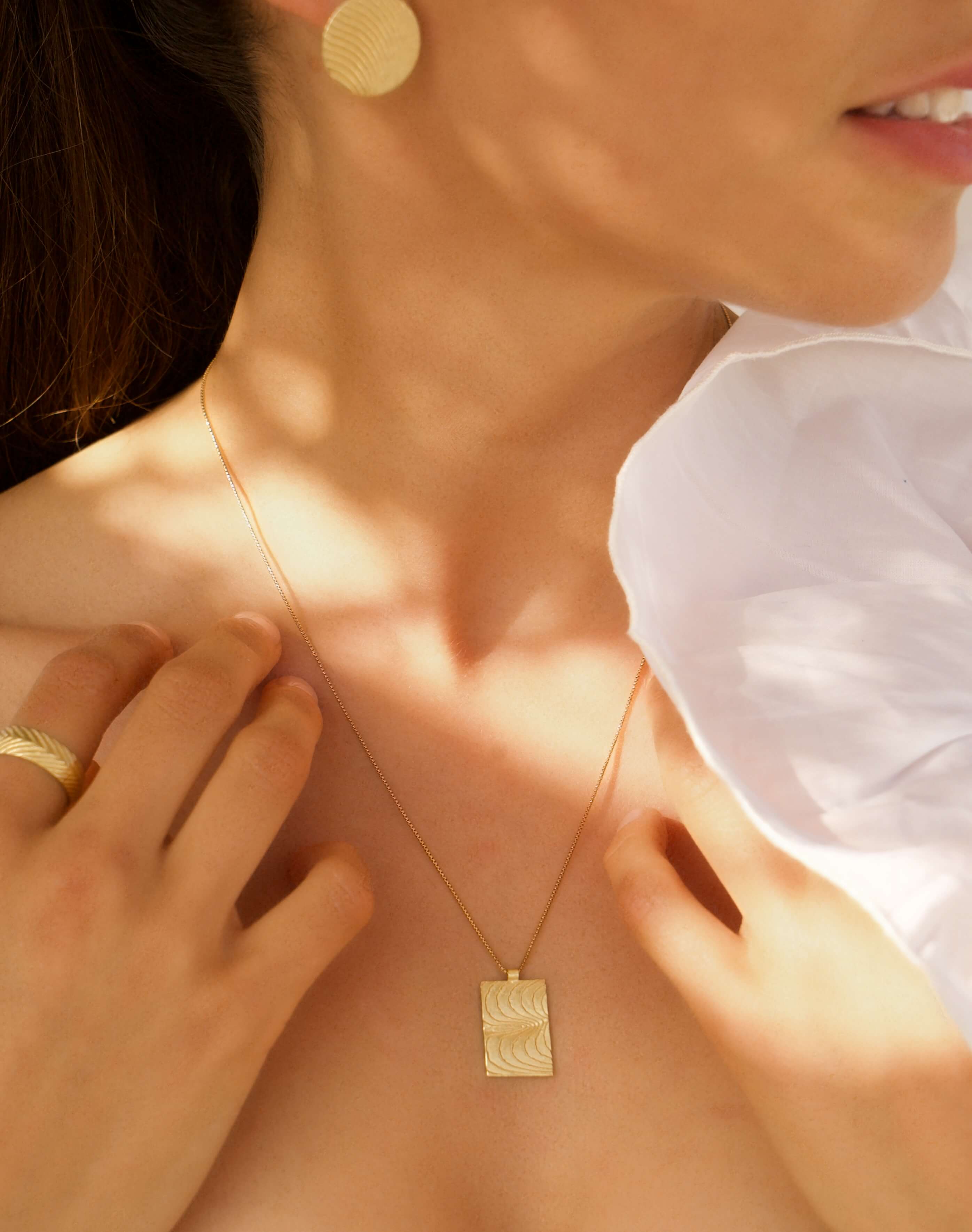Goldenes Rechteck mit maritimen Wellen. Das Geheimnis toller Frauen lliegt in ihrer Authentizität und ihrem Mut, besonderen Schmuck zu tragen