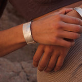 Das Dune Bracelet in Silber ist ein Piece of Art für das Handgelenk. Die wellenartigen Strukturen erzählen von Sediment, von Sanddünen und vom Meeresboden