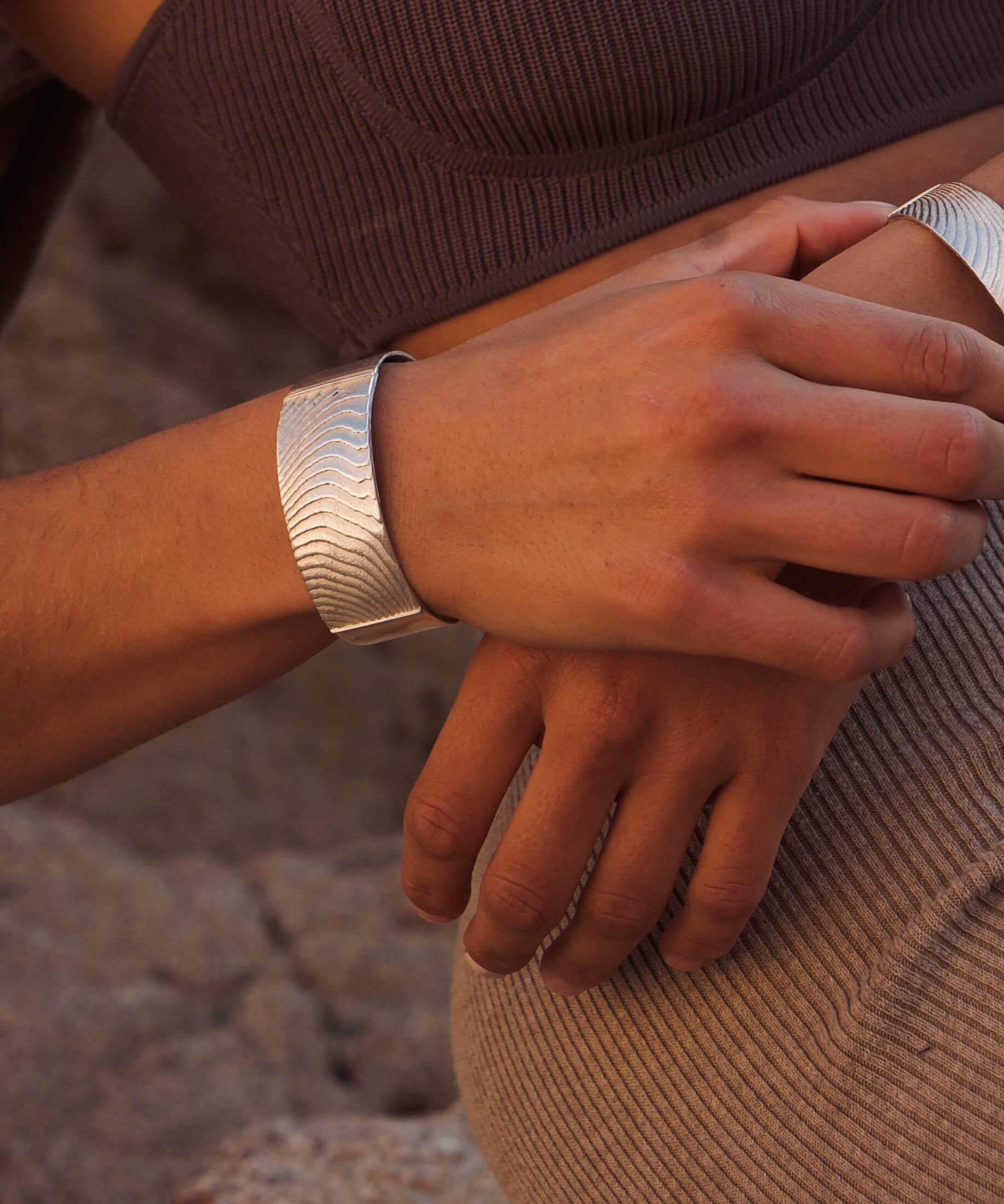 Das Dune Bracelet in Silber ist ein Piece of Art für das Handgelenk. Die wellenartigen Strukturen erzählen von Sediment, von Sanddünen und vom Meeresboden