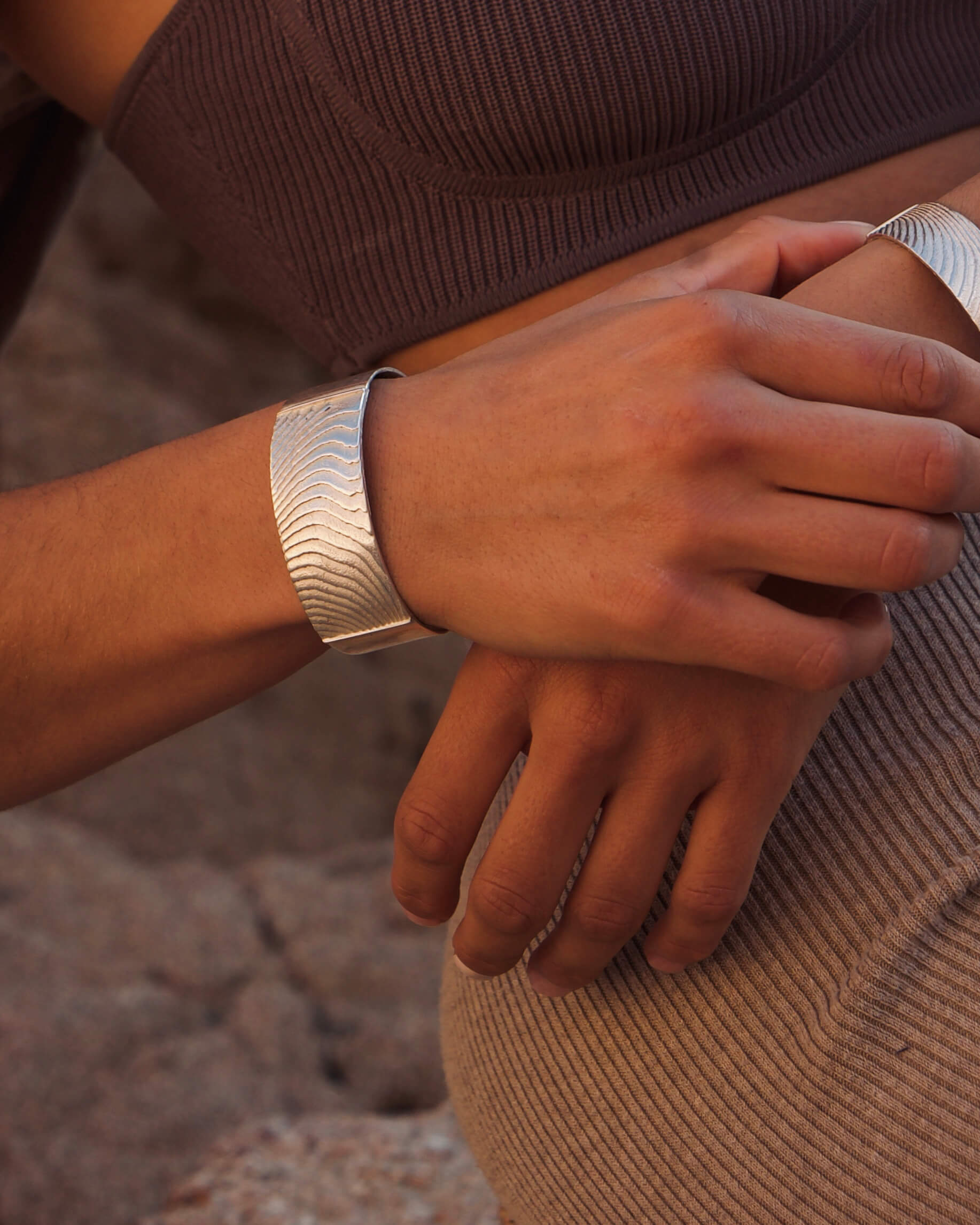 Das Dune Bracelet in Silber ist ein Piece of Art für das Handgelenk. Die wellenartigen Strukturen erzählen von Sediment, von Sanddünen und vom Meeresboden