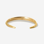 Der zierliche goldene Armreif mit feiner Meeresstruktur auf der Rückseite