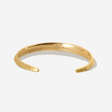 Der zierliche goldene Armreif mit feiner Meeresstruktur auf der Rückseite