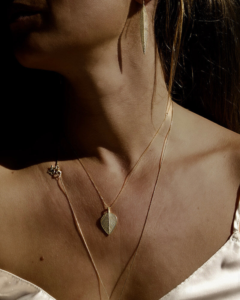Die symmetrische Blattstruktur des goldenen Minthe Necklace stammt aus der Meerestiefe. Es zentriert dich mental, strahlt Ruhe und die Kraft des Ozeans aus.