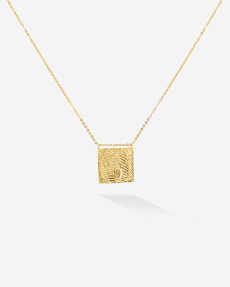 Das goldene Sandy Necklace erinnert dich durch die Meeressrtuktur der Sepien auf der Rückseite an sonnige Tage am Meer, wann immer du es trägst